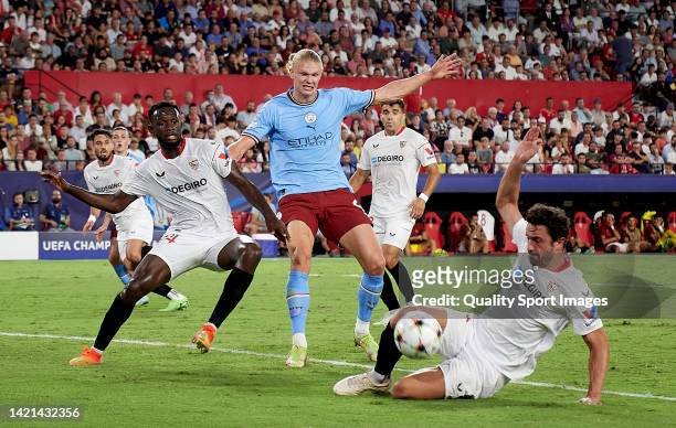 Erling Haaland of Manchester City competes for the ball with Tanguy-Austin Nianzou Kouassi of Sevilla and Thomas Delaney of Sevilla during the UEFA...