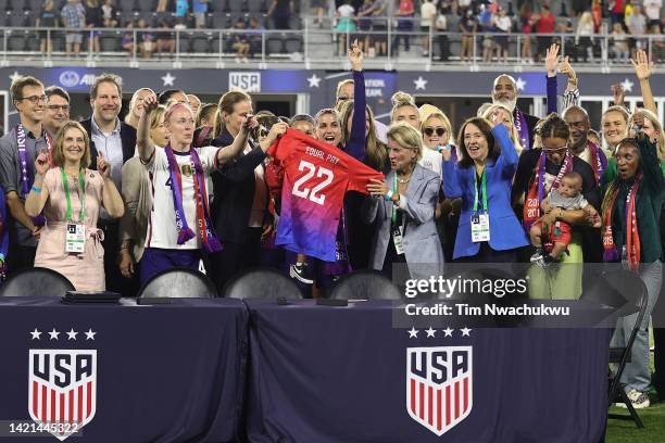 Members of U.S. Soccer, the U.S. Women's National Team Players Association and other dignitaries pose for a photo after signing a collective...