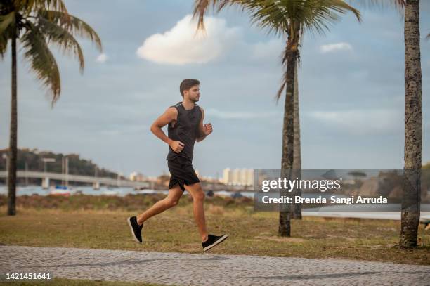 young man running on the street - man running on a road stock pictures, royalty-free photos & images