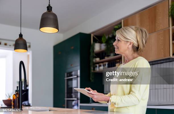 frau, die die lichter mit einem automatisierten system steuert - dimmer stock-fotos und bilder