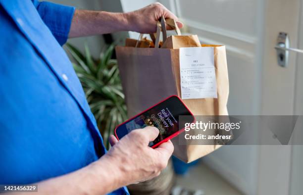 man rating his experience on the app after ordering food to his house - ordering food stock pictures, royalty-free photos & images