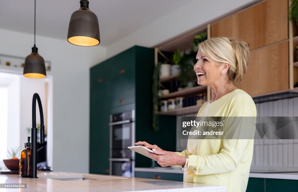 Woman controlling the lights of her smart home with a tablet