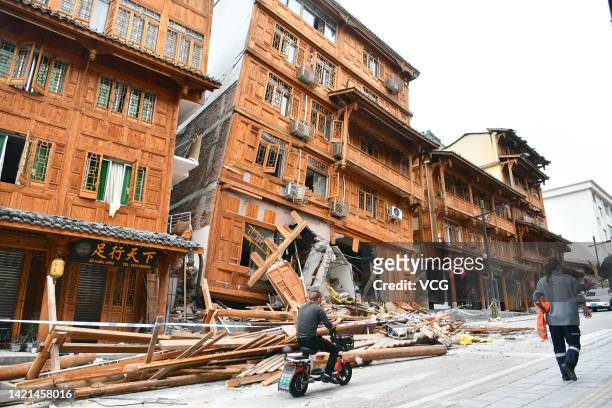 People walk by damaged buildings in Moxi town on September 6, 2022 in Luding County, Garze Tibetan Autonomous Prefecture, Sichuan Province of China....