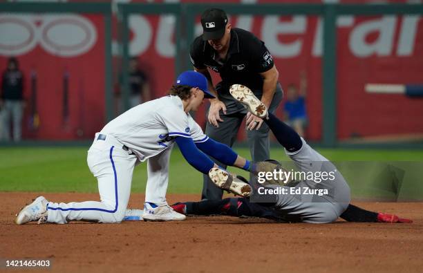 Andres Gimenez of the Cleveland Guardians is tagged out by shortstop Bobby Witt Jr. #7 of the Kansas City Royals as he tries to stretch a single in...