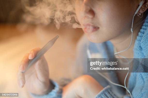 young woman relaxing with nicotine - vaping imagens e fotografias de stock