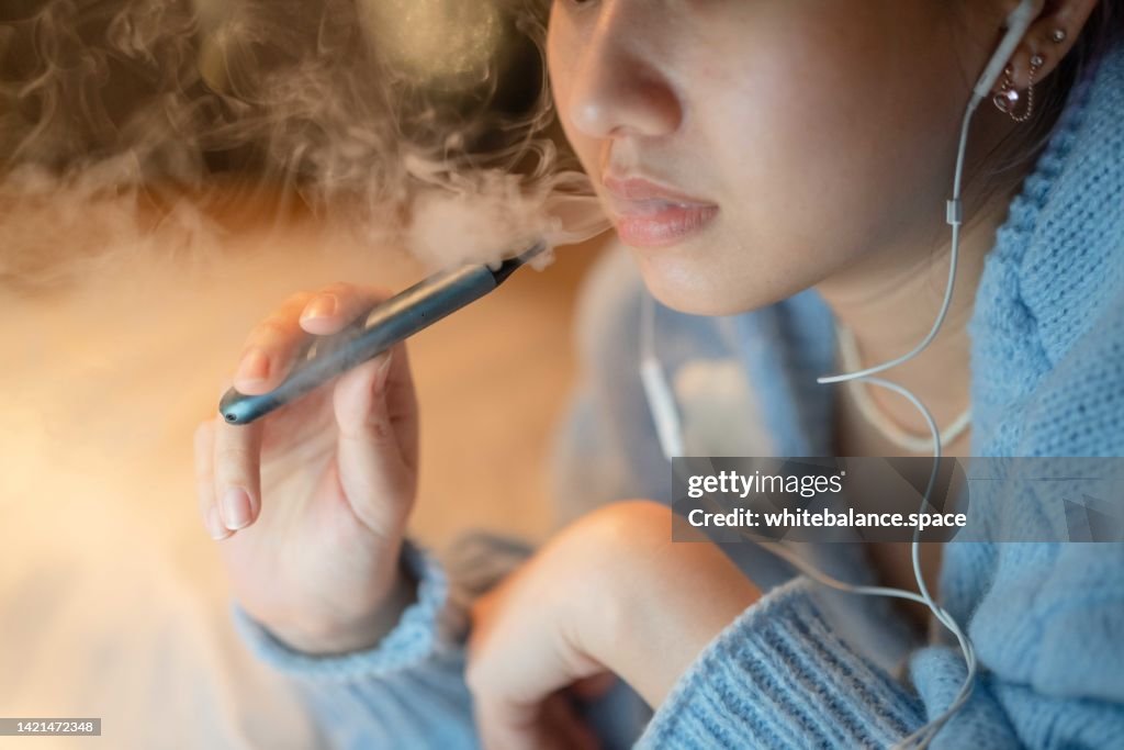 Stressful woman smoking electronic cigarette for relax.