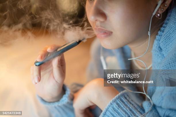stressful woman smoking electronic cigarette for relax. - world health organisation calls for regulation of ecigarettes stockfoto's en -beelden