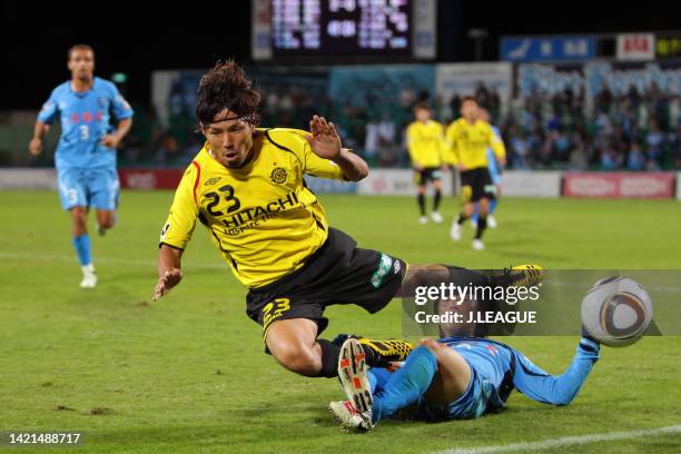 Yohei Kurakawa of Kashiwa Reysol is tackled by Shinichi Terada of Yokohama FC during the J.League J2 match between Kashiwa Reysol and Yokohama FC at...