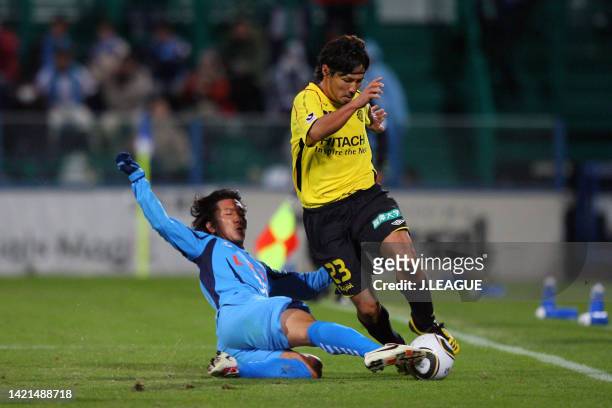 Yohei Kurakawa of Kashiwa Reysol is tackled by Shinichi Terada of Yokohama FC during the J.League J2 match between Kashiwa Reysol and Yokohama FC at...