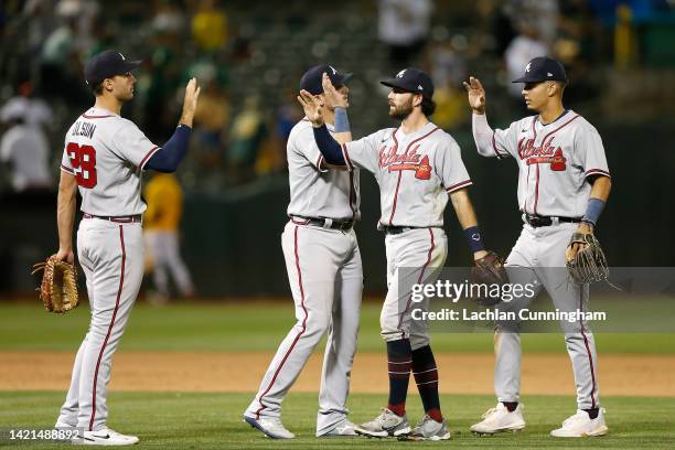 Matt Olson, Austin Riley, Dansby Swanson and Vaughn Grissom of the Atlanta Braves celebrate after a win against the Oakland Athletics at RingCentral...