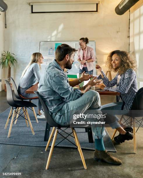 happy freelancers talking while having a casual meeting in the office. - freelance work candid stock pictures, royalty-free photos & images