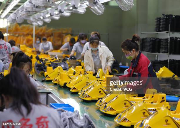 Employees work on the assembly line of electric toy cars for kids at a factory on September 6, 2022 in Guangzong County, Xingtai City, Hebei Province...