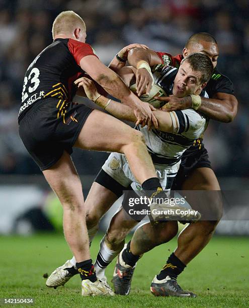 Martin Aspinwall of Hull FC is tackled by Danny Addy and Manase Manuokafoa of Bradford during the Stobart Super League match between Hull FC and...