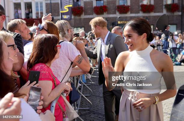 Prince Harry, Duke of Sussex and Meghan, Duchess of Sussex meet members of the public as they leave the town hall during the Invictus Games...