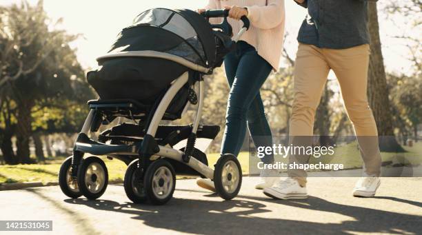 parents, baby stroller and exercise with a young man and woman pushing a pram while walking through a park on a sunny day. closeup feet of a young family out for an active leisure stroll in summer - buggy stock pictures, royalty-free photos & images