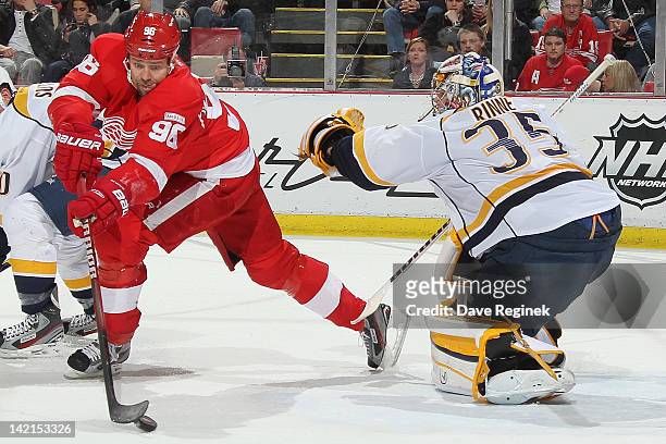 Tomas Holmstrom of the Detroit Red Wings handles the puck while Pekka Rinne the Nashville Predators tends net during an NHL game at Joe Louis Arena...