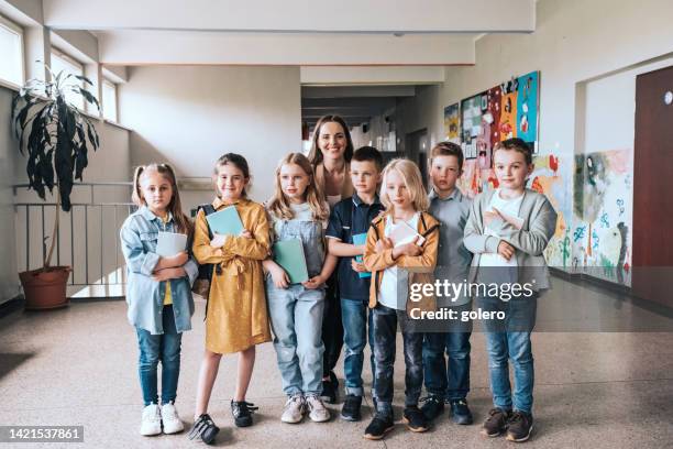 elementary school children with female teacher in a row for class photo - skolfoto bildbanksfoton och bilder