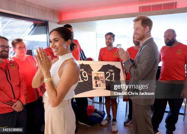 Meghan, Duchess of Sussex and Prince Harry, Duke of Sussex are presented with sports shirts with their children's names on them by Invictus athletes...