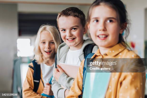 three elementary school children  in a row - skolfoto bildbanksfoton och bilder