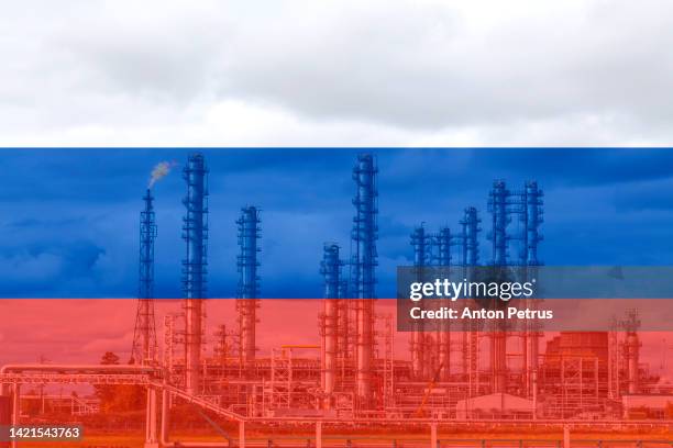 liquid natural gas plant on the background of of the russian flag - russische kultur stock-fotos und bilder