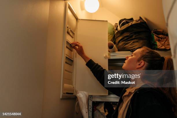 female electrician analyzing switchboard at home - electrical switchboard stock pictures, royalty-free photos & images