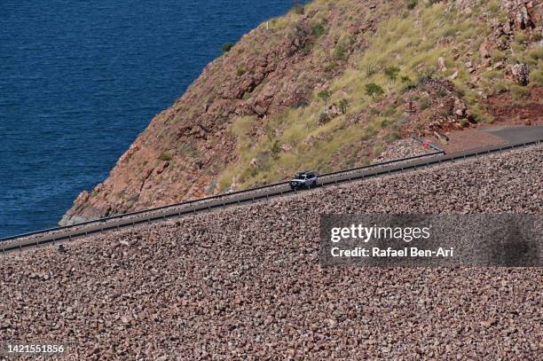 vehicle driving over ord river dam in lake argyle estern australia - driving car australia road copy space sunlight travel destinations colour image day getting stock pictures, royalty-free photos & images