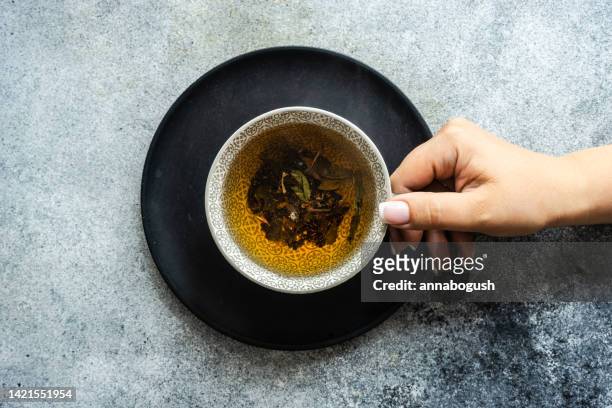 overhead view of a woman enjoying a cup of tea - cup of tea from above stock pictures, royalty-free photos & images