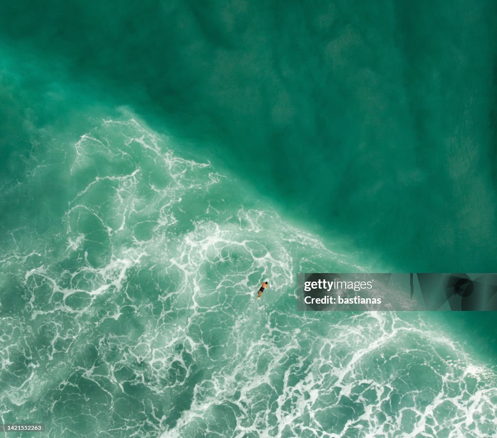 Aerial drone view of man on a surfboard in ocean surf, Nias Island, North Sumatra, Indonesia