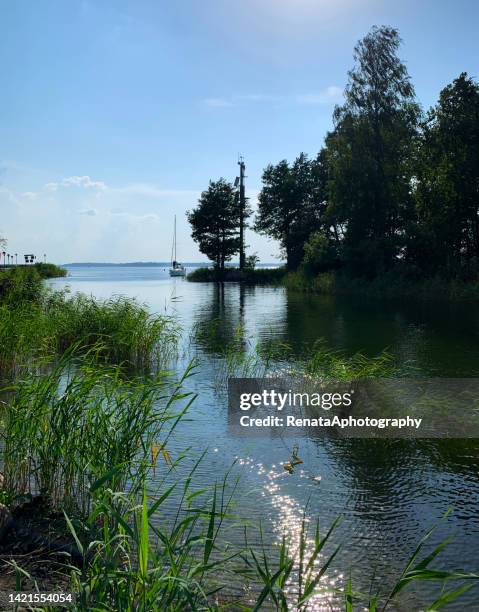 distant boat sailing on a lake in summer near gizycko, poland - gizycko stock pictures, royalty-free photos & images