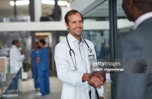 doctor shaking hands with corporate business man for deal, meeting and healthcare contract. handshake, consulting and b2b partnership in medical office for opportunity agreement and insurance support - doctor recruitment stock pictures, royalty-free photos & images