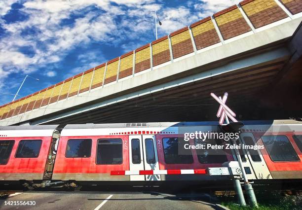 railroad crossing with boom barrier and train - budapest train stock pictures, royalty-free photos & images