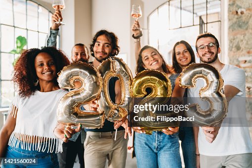 Friends are holding golden balloons to celebrate the new year 2023 Friends are holding golden balloons to celebrate the new year 2023