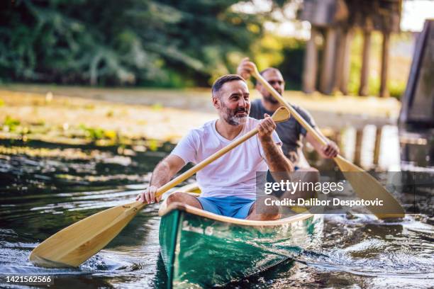 two men are rowing on the river - middle aged man hobby stock pictures, royalty-free photos & images