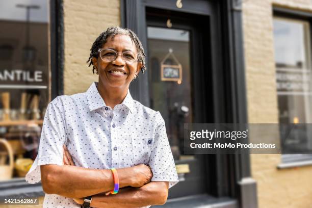 portrait of female small business owner in front of her store - lgbtqi people stock-fotos und bilder