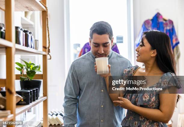 young couple shopping in a female owned small business - lekker ruikend stockfoto's en -beelden