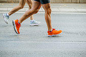 legs runners man and woman run on road marathon