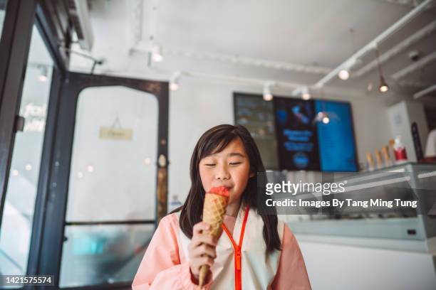 lovely cheerful girl enjoying ice cream in an ice cream shop - ice cream shop stock pictures, royalty-free photos & images