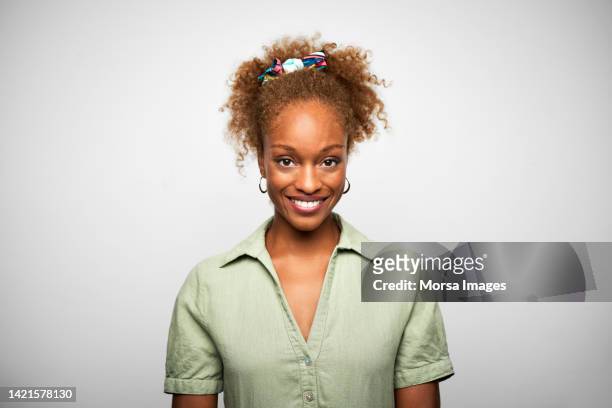 close-up portrait of young confident african american businesswoman is against white background. - african american young woman portrait white background stock-fotos und bilder