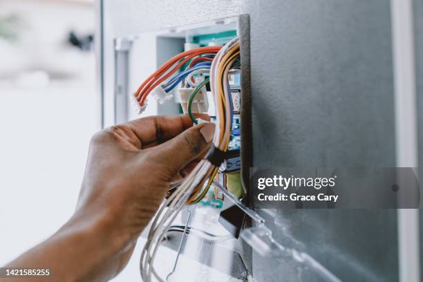 woman repairs refrigerator's core circuit board - metalldraht stock-fotos und bilder