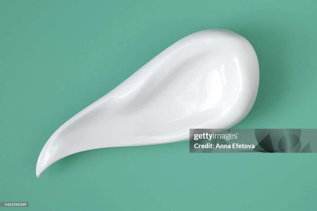 Cream smear with nourishing and moisturizing ingredients: hyaluronic acid, polyglutamic acid or serum with peptides, ceramides, retinol molecules. Flat lay style