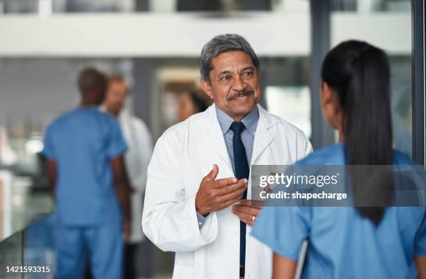 doctors or healthcare worker consulting nurse about medical results and surgery at a clinic. a professional cardiology team with teamwork and support for diagnosis and treatment plan in the hospital - doctor lab coat stockfoto's en -beelden