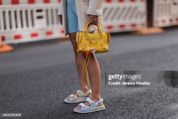 Palina Kozyrava is seen wearing light blue cycling shorts, light beige oversize blazer from H&M, yellow leather Balenciaga Neo Cagole bag and light...