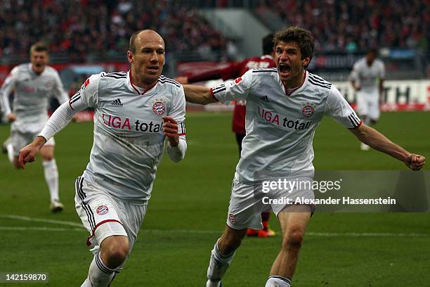 Arjen Robben of Muenchen celebrates scoring the first goal with his team mate Thomas Mueller during the Bundesliga match between 1.FC Nuernberg and...