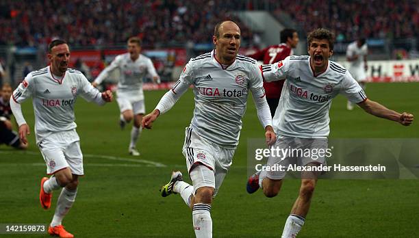 Arjen Robben of Muenchen celebrates scoring the first goal with his team mate Thomas Mueller and Franck Ribery during the Bundesliga match between...