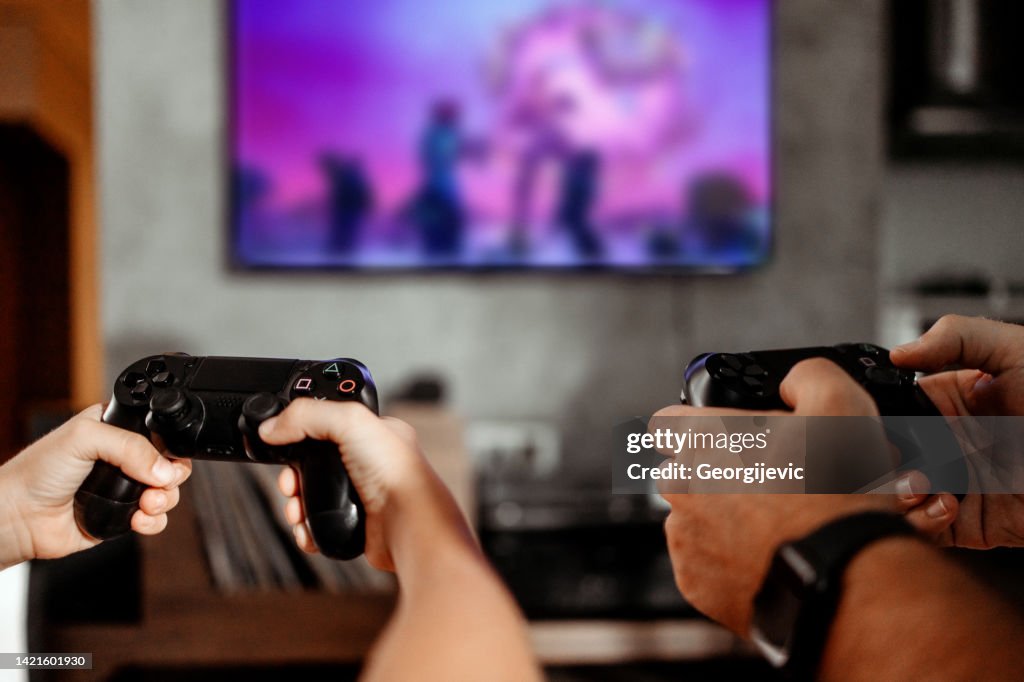 Father and son playing video games at home