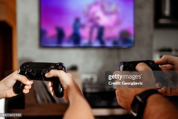 father and son playing video games at home - gamepad stock pictures, royalty-free photos & images