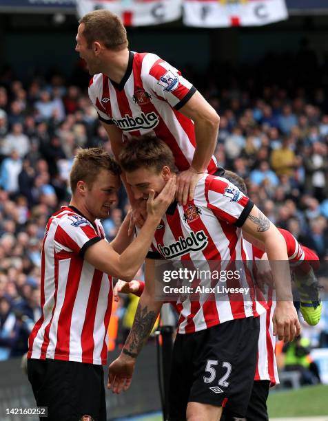 Sebastian Larsson of Sunderland celebrates scoring his team's third goal with Nickals Bendtner during the Barclays Premier League match between...