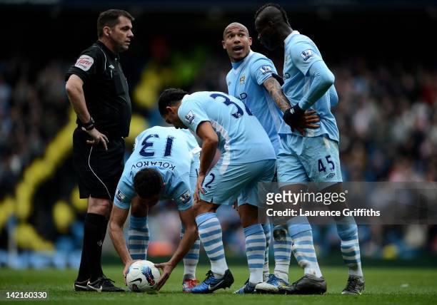 Mario Balotelli of Manchester City is restrained by team mate Nigel de Jong during the Barclays Premier League match between Manchester City and...