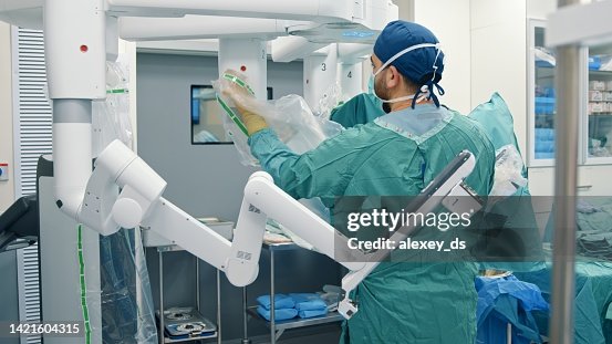 Operating room nurse preparing a surgical robot for surgery Operating room nurse preparing a surgical robot for surgery