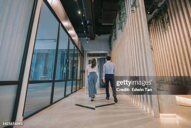 2 asian chinese colleague walking in corridor on the way out for lunch - 2 people back asian imagens e fotografias de stock